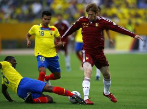 Venezuela's Aristequieta is tackled by Ecuador's Campos as his teammate Saritana looks on during their World Cup 2014 qualifying soccer match in Quito