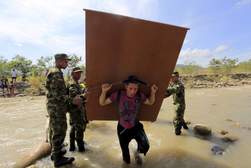 A man carries a furniture as he crosses the Tachira river border into Colombia from Venezuela, near Colombia's Villa del Rosario village