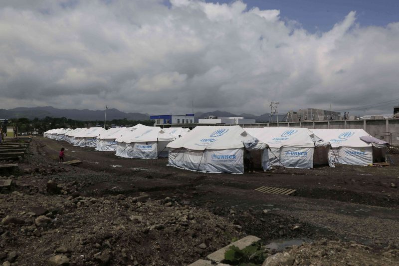 In this May 15, 2016 photo, tents set up for people displaced by last month's earthquake stand in rows at the new bus terminal in Pedernales, Ecuador. A month after the magnitude 7.8 earthquake many Ecuadorians are still struggling. (AP Photo/Dolores Ochoa)