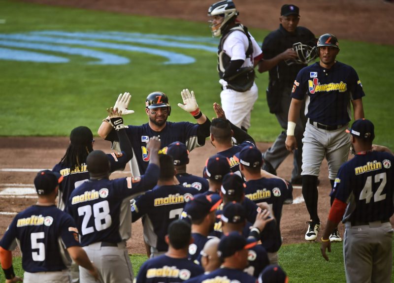 Jesus Flores (C) of Aguilas del Zulia from Venezuela celebrates with teammates after scoring against Criollos de Caguas from Puerto Rico, during the Caribbean Baseball Series, at the Tomateros stadium in Culiacan, Sinaloa state, Mexico, on February 2, 2017. / AFP PHOTO / RONALDO SCHEMIDT