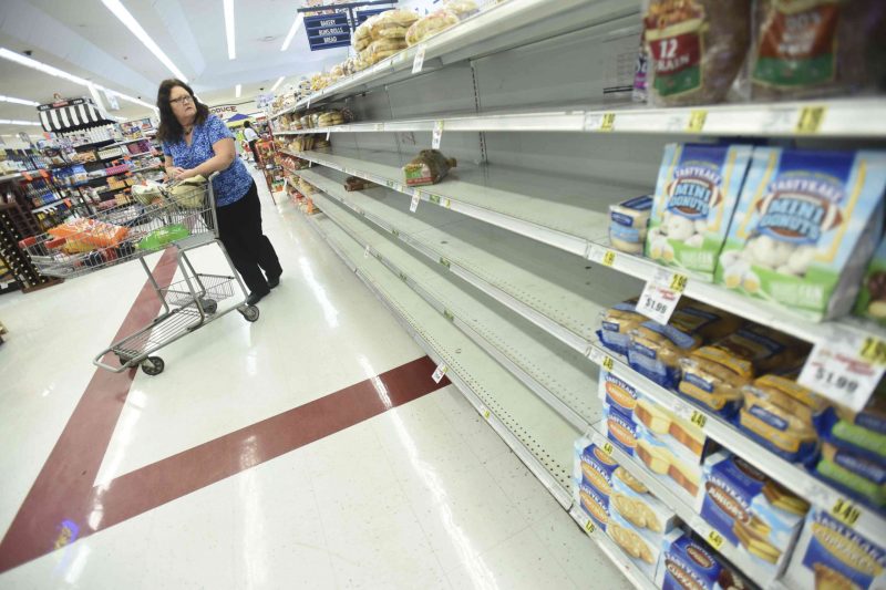 Mary Stanley looks at the empty shelves on a bread isle at the Piggly Wiggly grocery store in Leland, N.C., on Wednesday, Oct. 5, 2016. Forecasters said Hurricane Matthew could hit Florida — or come dangerously close — late Thursday or early Friday and then scrape the East Coast all the way up to the Carolinas over the weekend. (Ken Blevins/The Star-News via AP) /The Star-News via AP)