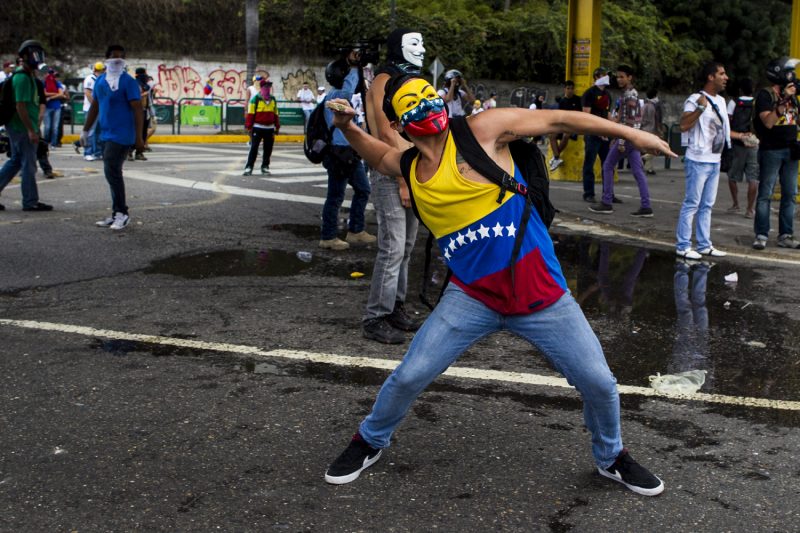 CAR22. CARACAS (VENEZUELA), 26/02/2014.- Un manifestante con la cara cubierta participa en una protesta contra el gobierno del presidente venezolano Nicolás Maduro hoy, jueves 27 de febrero del 2014, en Caracas (Venezuela). Venezuela se encuentra inmersa en una oleada de protestas desde que el pasado día 12 murieron tres jóvenes en actos de violencia tras una manifestación pacífica de estudiantes y opositores en Caracas. Hasta el momento, hay 13 muertos vinculados a las protestas, saldo que se eleva a 16 según versiones de prensa, y más de 150 heridos. EFE/MIGUEL GUTIÈRREZ
